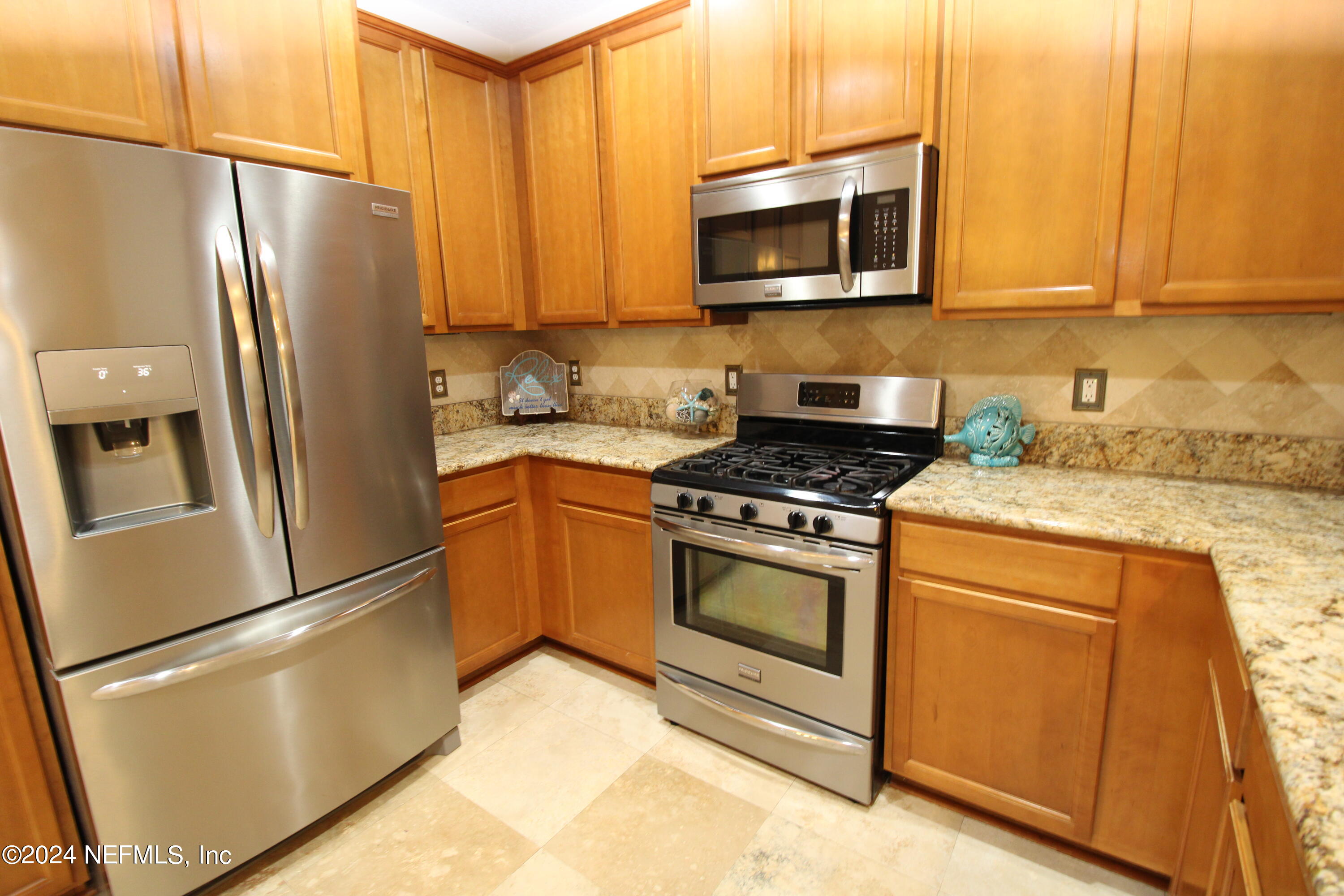 28 Grand Ravine Drive St. Augustine, FL 32086 - Photo 14 of 55 a kitchen with granite countertop a refrigerator stove and microwave