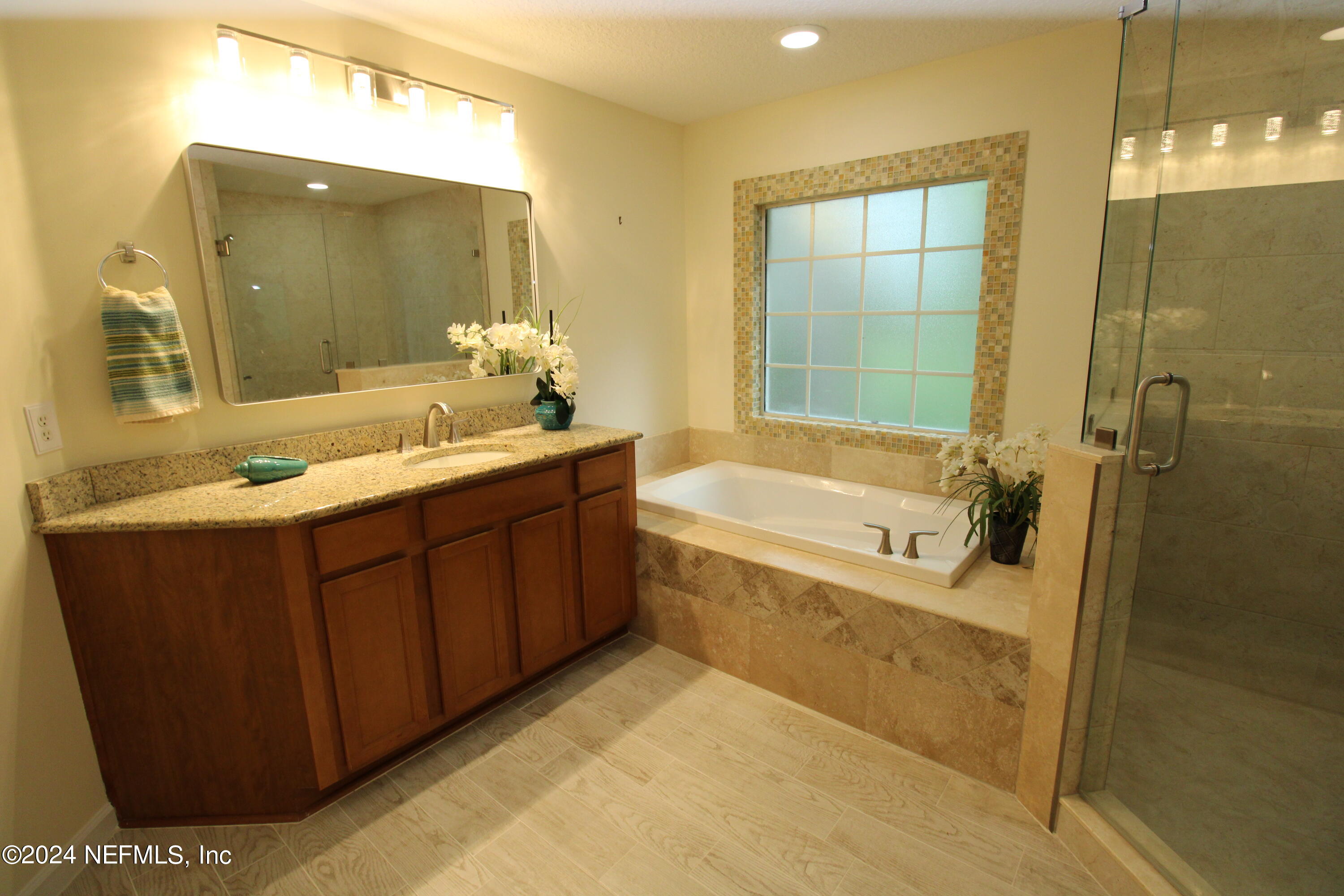 28 Grand Ravine Drive St. Augustine, FL 32086 - Photo 24 of 55 a bathroom with a tub sink shower and mirror
