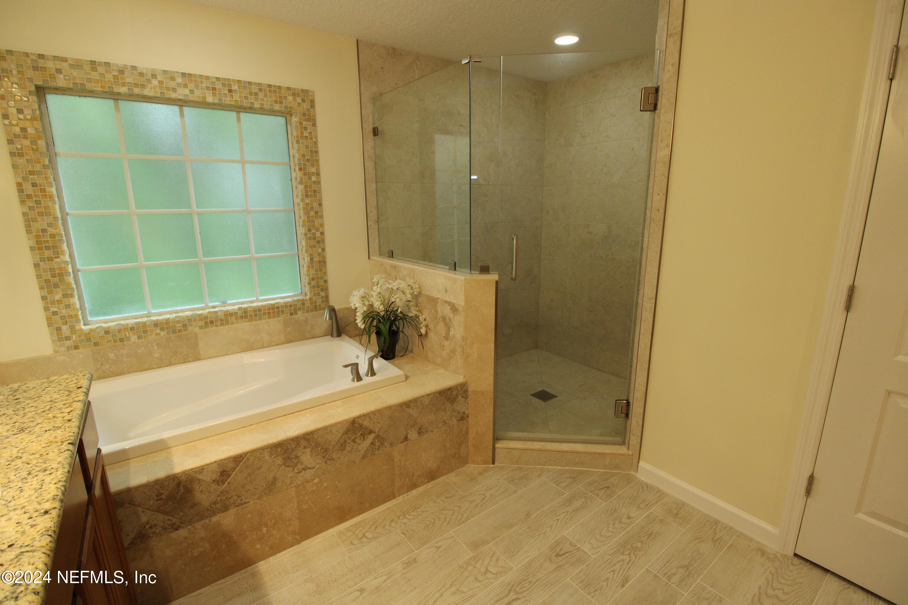 28 Grand Ravine Drive St. Augustine, FL 32086 - Photo 25 of 55 a bathroom with a bathtub and a shower
