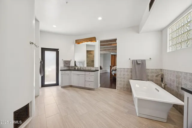 a bathroom with a granite countertop sink mirror and a bathtub