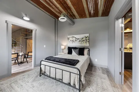 a spacious bedroom with a bed and a dresser
