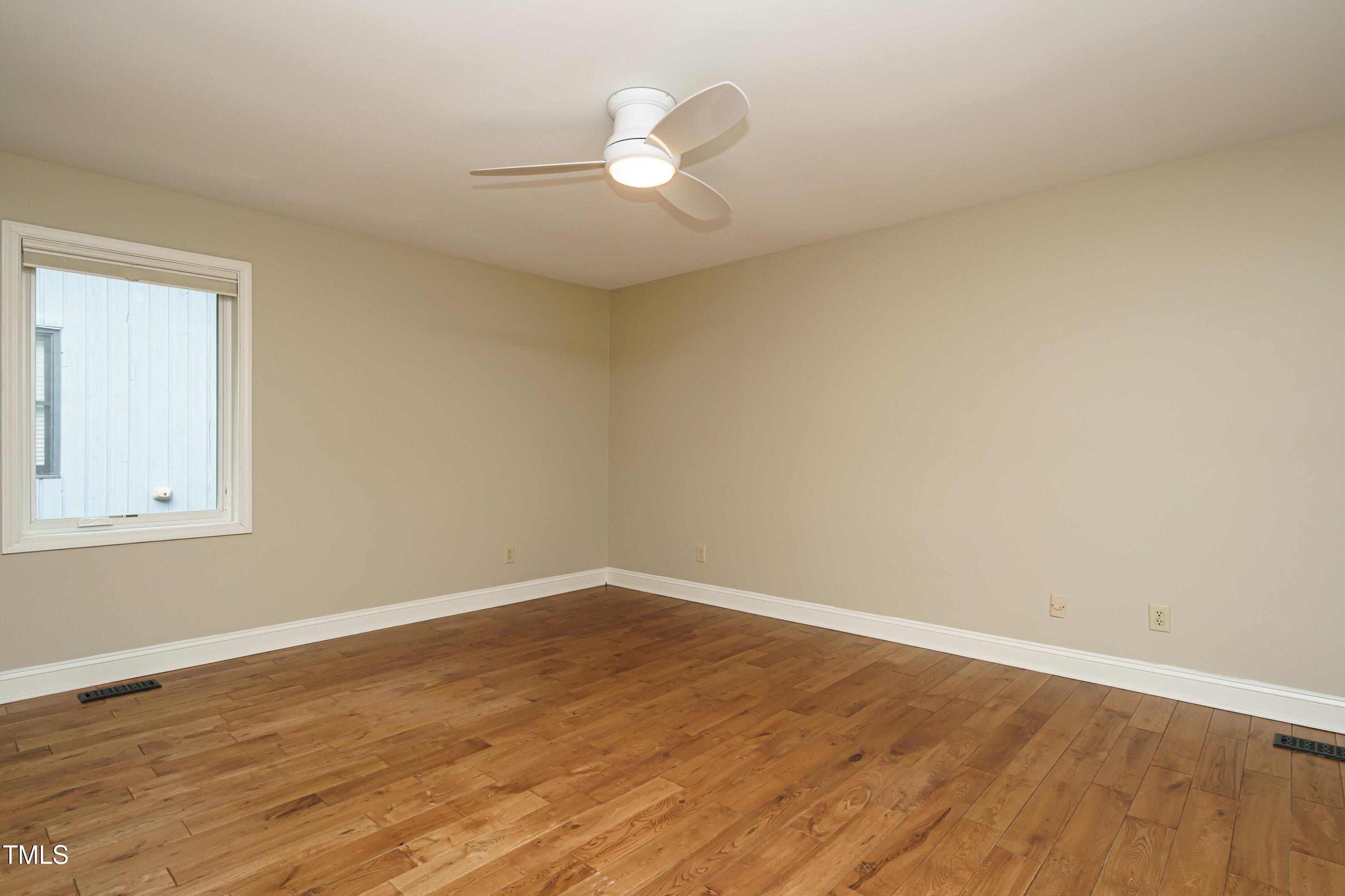2916 Rue Sans Famille Raleigh, NC 27607 - Photo 22 of 32 a view of a room with wooden floor and a ceiling fan