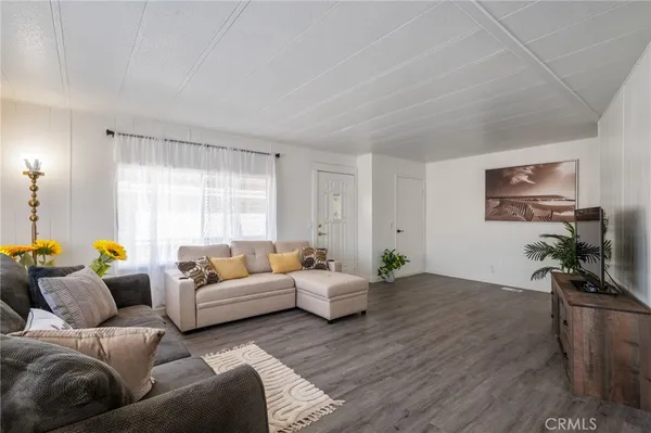 a living room with furniture a window and a wooden floor