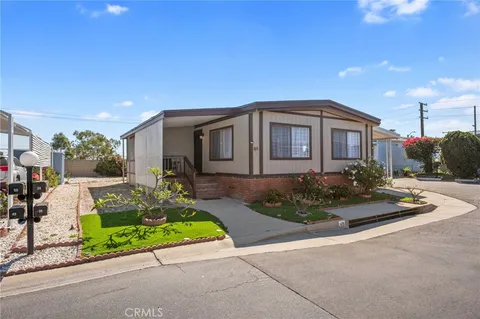 a front view of a house with a yard and potted plants