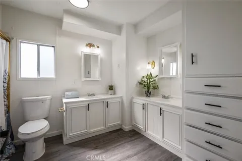 a spacious bathroom with a toilet a sink and mirror