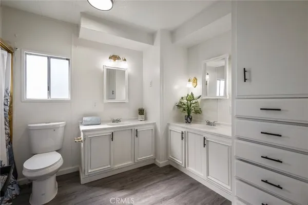 a spacious bathroom with a toilet a sink and mirror
