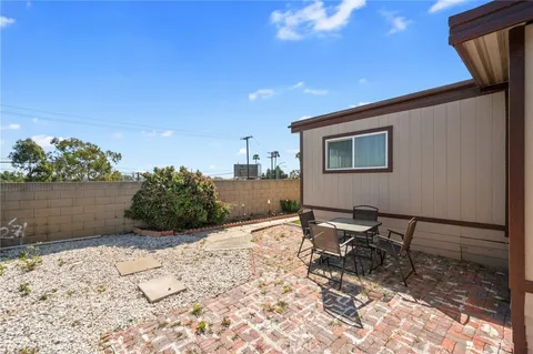 a patio with table and chairs and potted plants