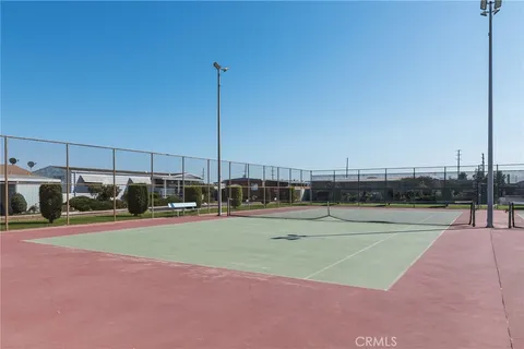 a view of a tennis ground with large trees
