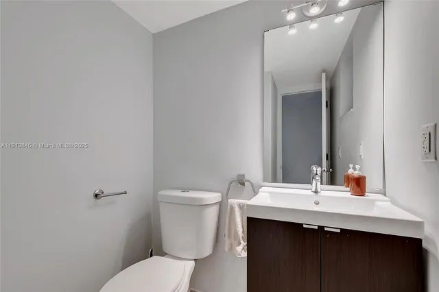 a bathroom with a sink toilet and mirror