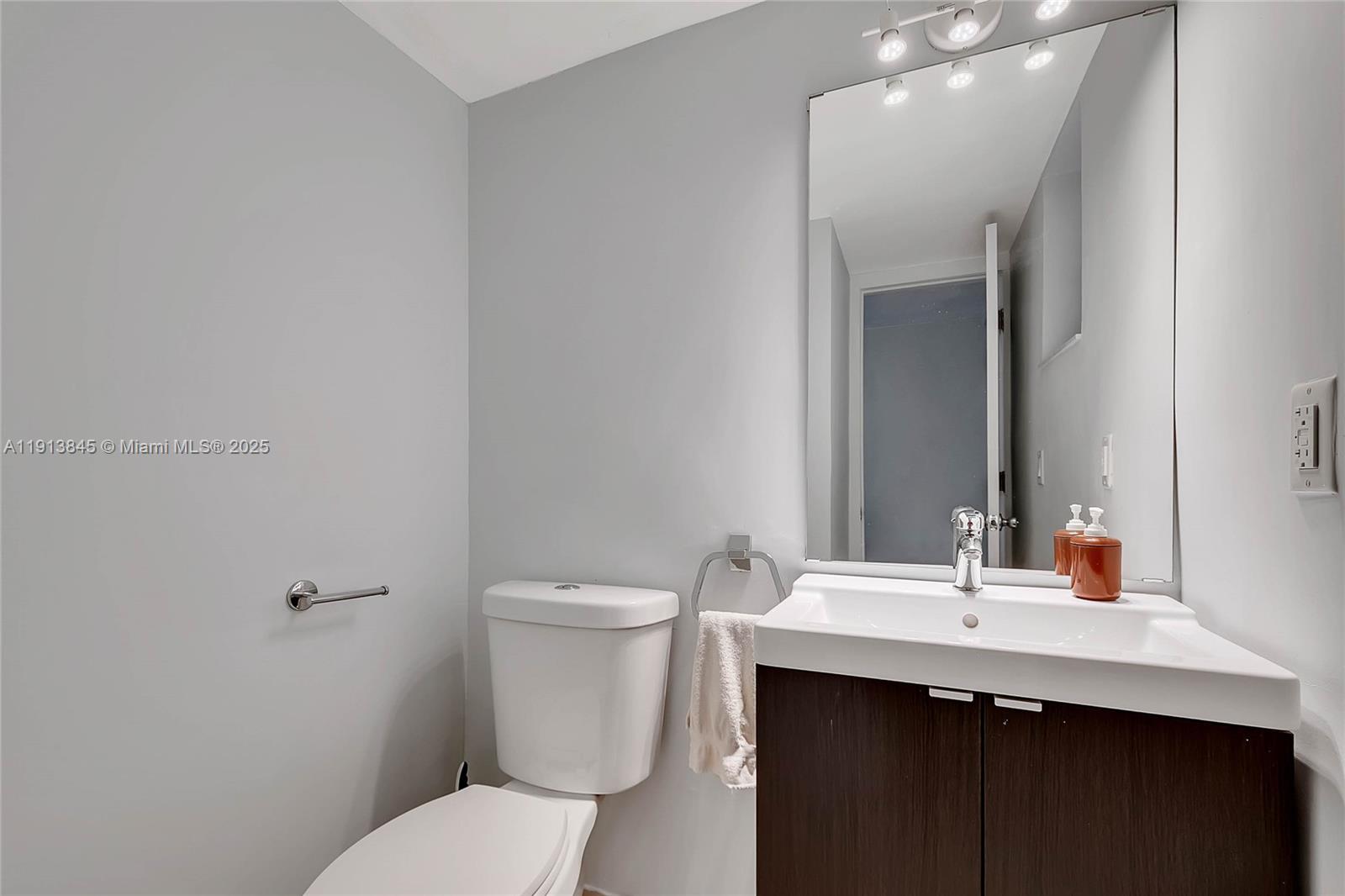100 Ocean Ln Drive, Unit 202 Key Biscayne, FL 33149 - Photo 13 of 22 a bathroom with a sink toilet and mirror