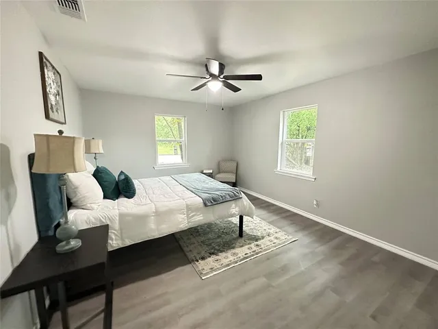 a bedroom with a bed and wooden floor