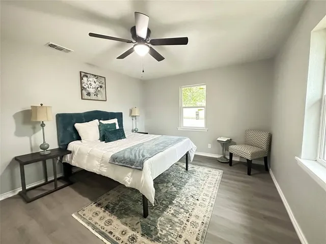 a bedroom with a bed and wooden floor