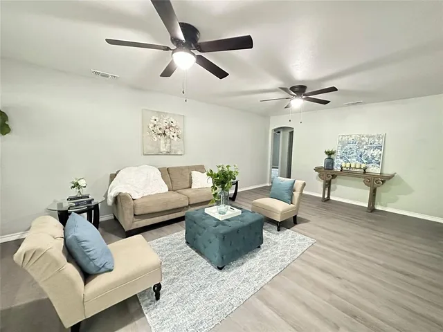 a living room with furniture and a wooden floor