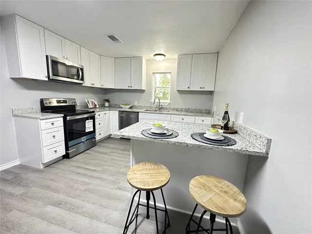a kitchen with a table chairs stove and microwave