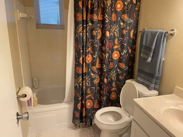 a white toilet sitting next to a bathroom sink and tub