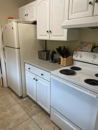 a kitchen with refrigerator and cabinets
