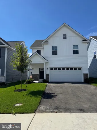 a front view of a house with a yard and trees