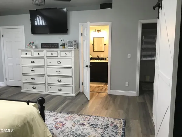 a view of a bedroom with wooden floor and cabinet