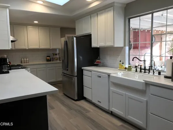 a kitchen with a sink a refrigerator and cabinets
