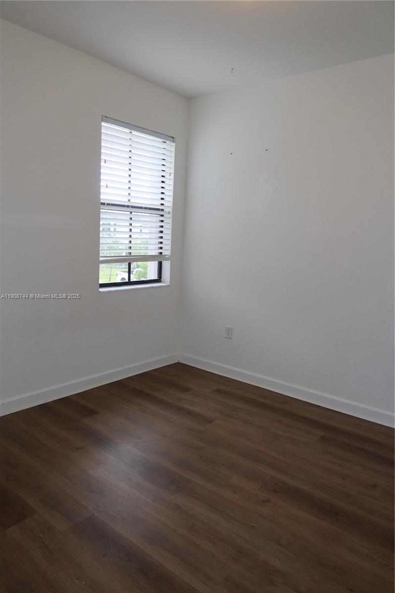 18240 Southwest 148th Road, Unit 18240 Miami, FL 33187 - Photo 18 of 30 an empty room with wooden floor and windows