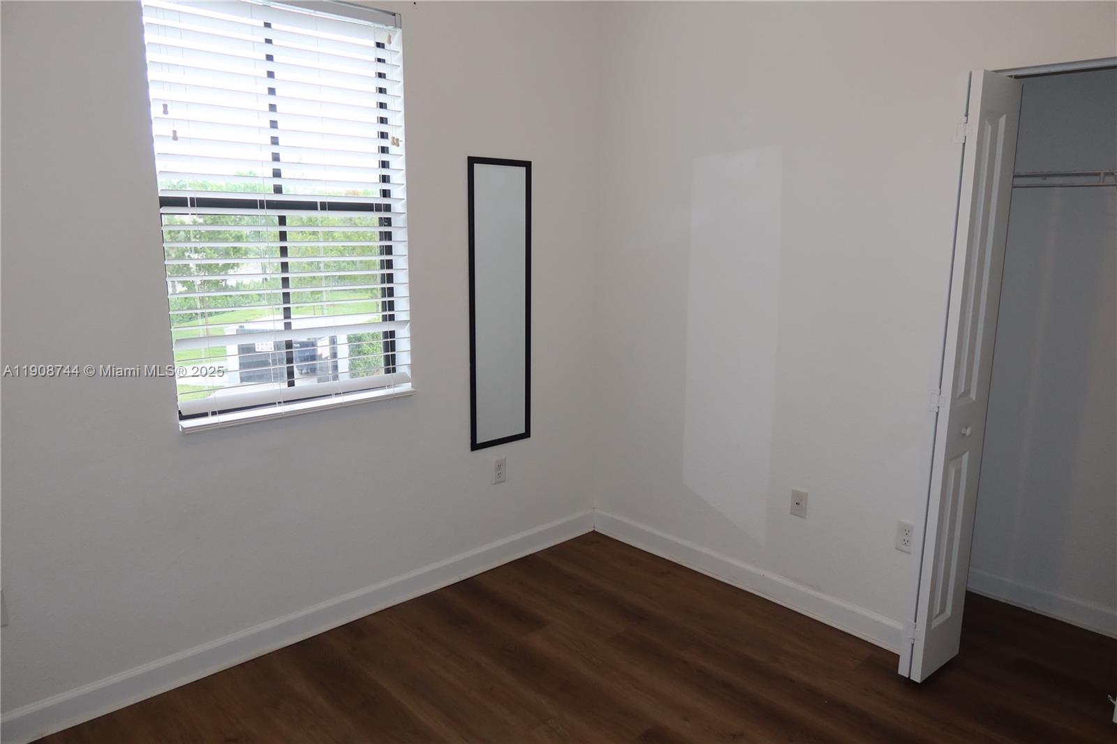 18240 Southwest 148th Road, Unit 18240 Miami, FL 33187 - Photo 22 of 30 an empty room with wooden floor and windows
