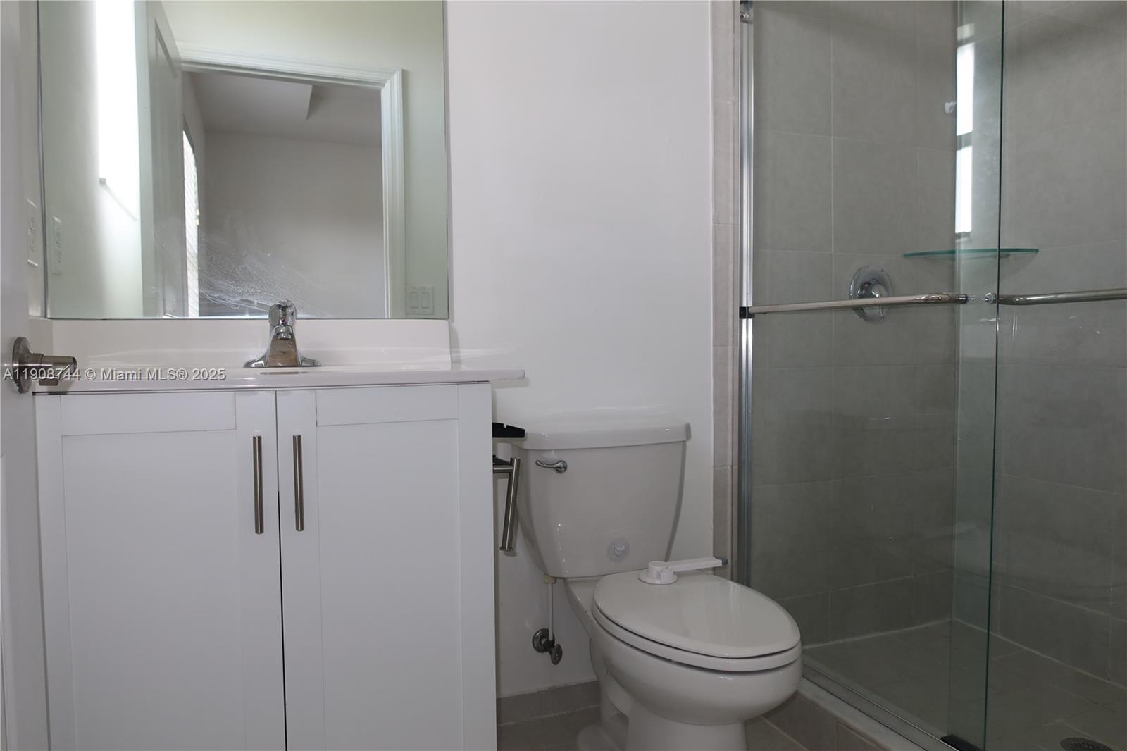 18240 Southwest 148th Road, Unit 18240 Miami, FL 33187 - Photo 28 of 30 a bathroom with a granite countertop toilet sink and mirror