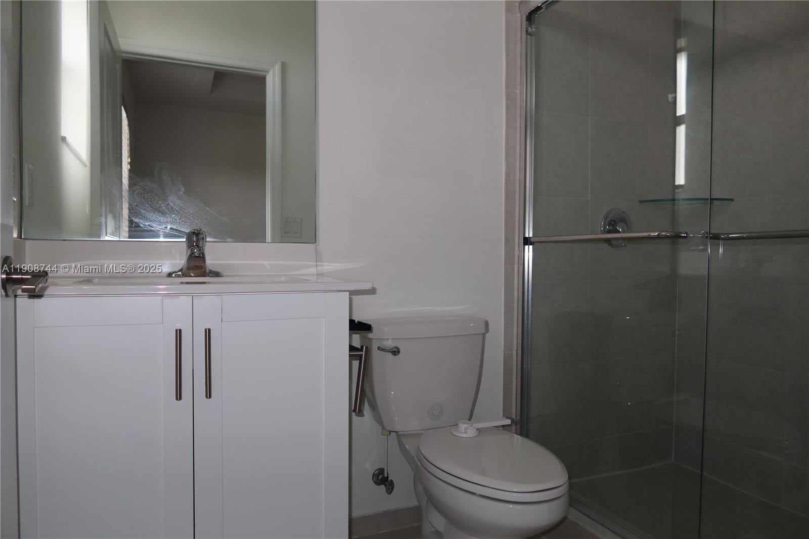 18240 Southwest 148th Road, Unit 18240 Miami, FL 33187 - Photo 29 of 30 a bathroom with a granite countertop toilet sink and mirror