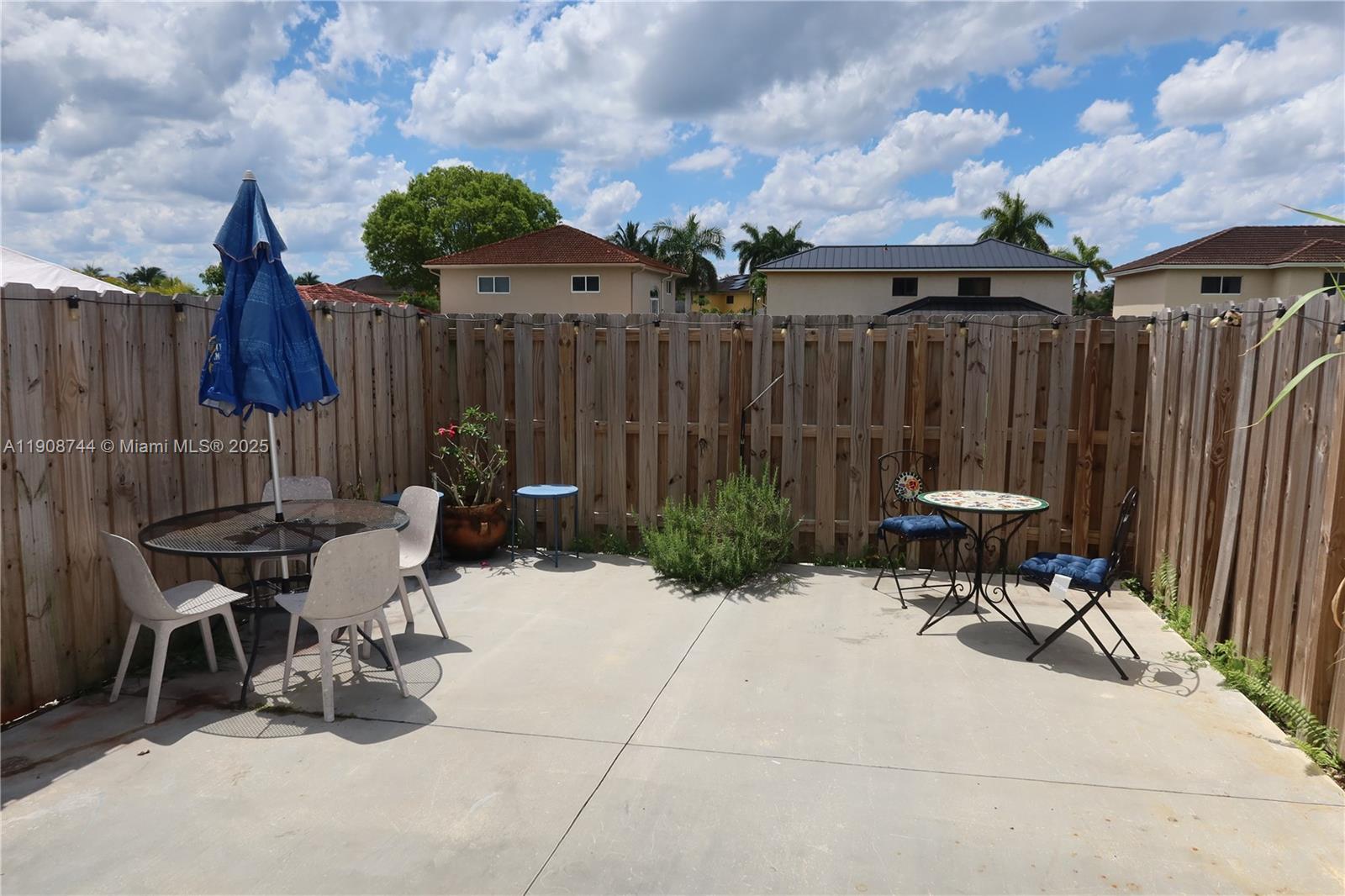18240 Southwest 148th Road, Unit 18240 Miami, FL 33187 - Photo 10 of 30 a view of a chairs and table in backyard