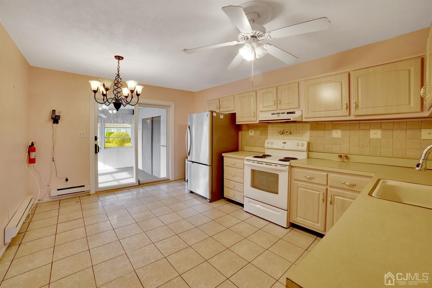 136 Rigi Strasse, Unit E Freehold, NJ 07728 - Photo 11 of 30 a kitchen with a stove a sink and a refrigerator