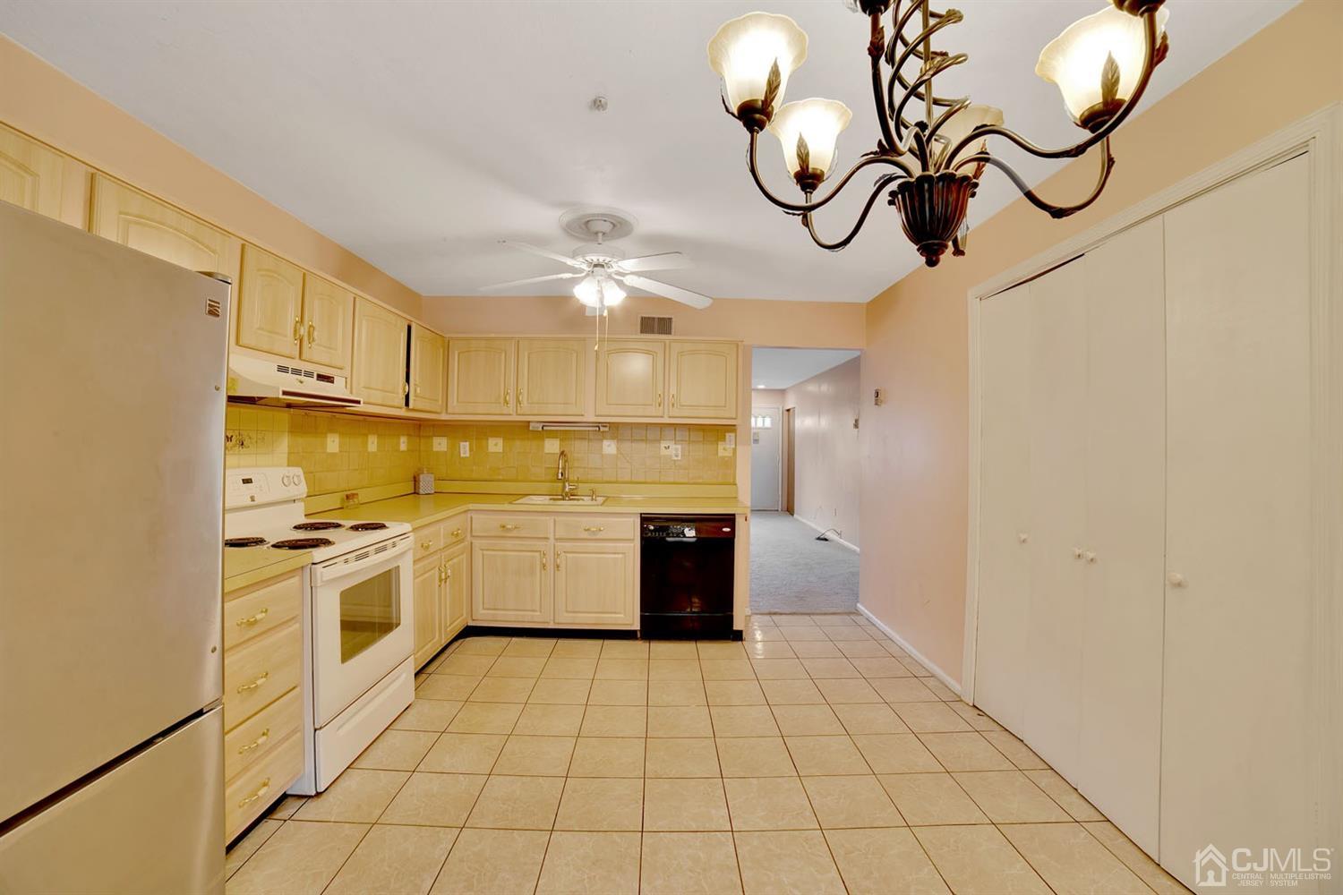 136 Rigi Strasse, Unit E Freehold, NJ 07728 - Photo 12 of 30 a kitchen with stainless steel appliances granite countertop a sink a stove top oven and cabinets