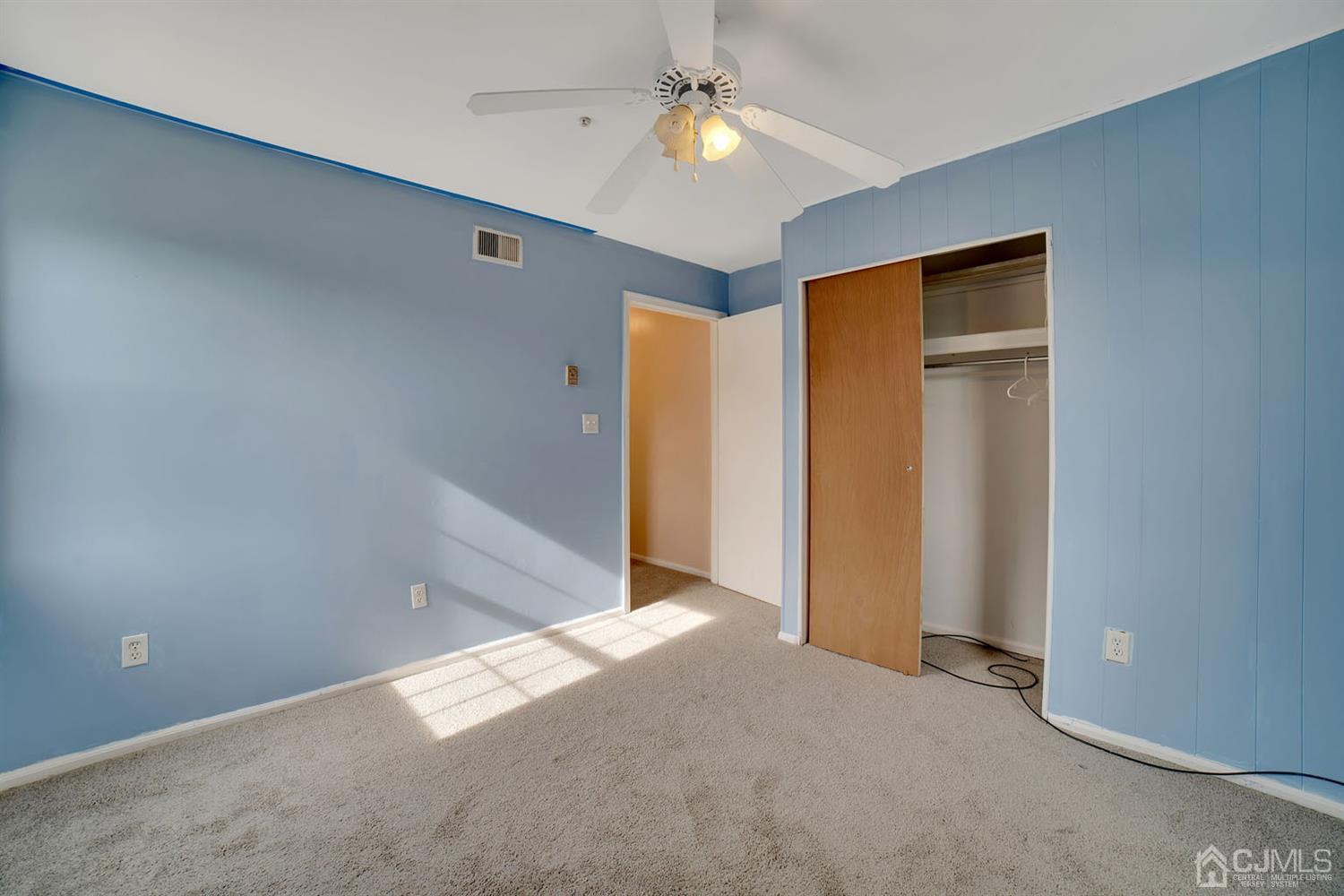 136 Rigi Strasse, Unit E Freehold, NJ 07728 - Photo 19 of 30 an empty room with closet and a ceiling fan