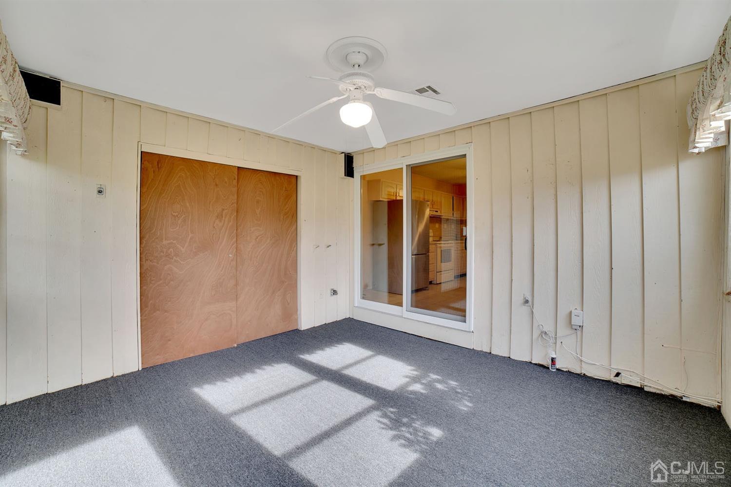 136 Rigi Strasse, Unit E Freehold, NJ 07728 - Photo 21 of 30 a view of an empty room with wooden floor and a window