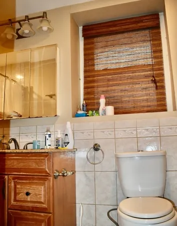 a bathroom with a toilet sink vanity and mirror