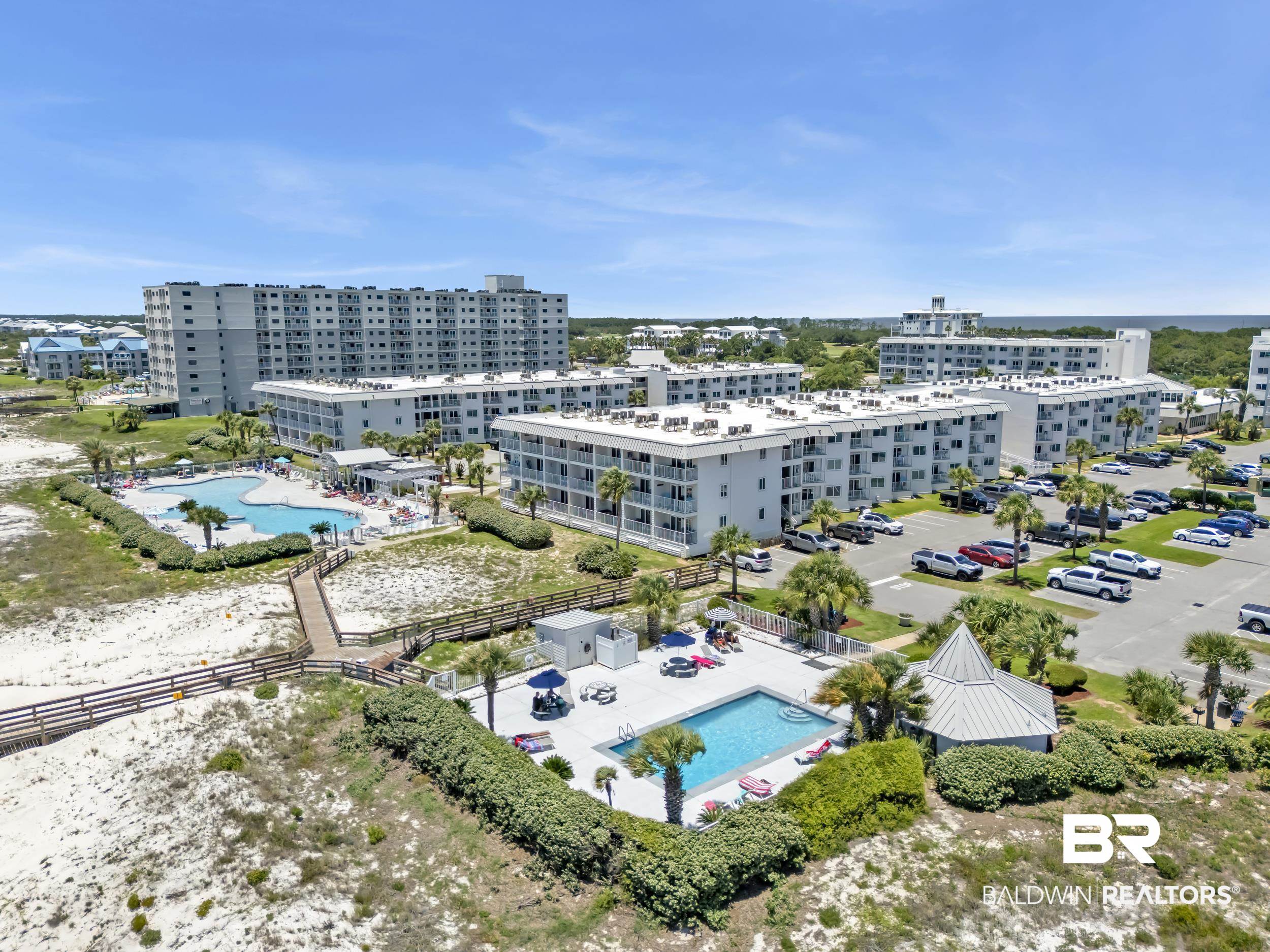 400 Plantation Road, Unit 2118 Gulf Shores, AL 36542 - Photo 49 of 59 Aerial perspective of a multi-building complex featuring multiple swimming pools, extensive parking areas, established landscaping, and a wooden boardwalk providing beach access