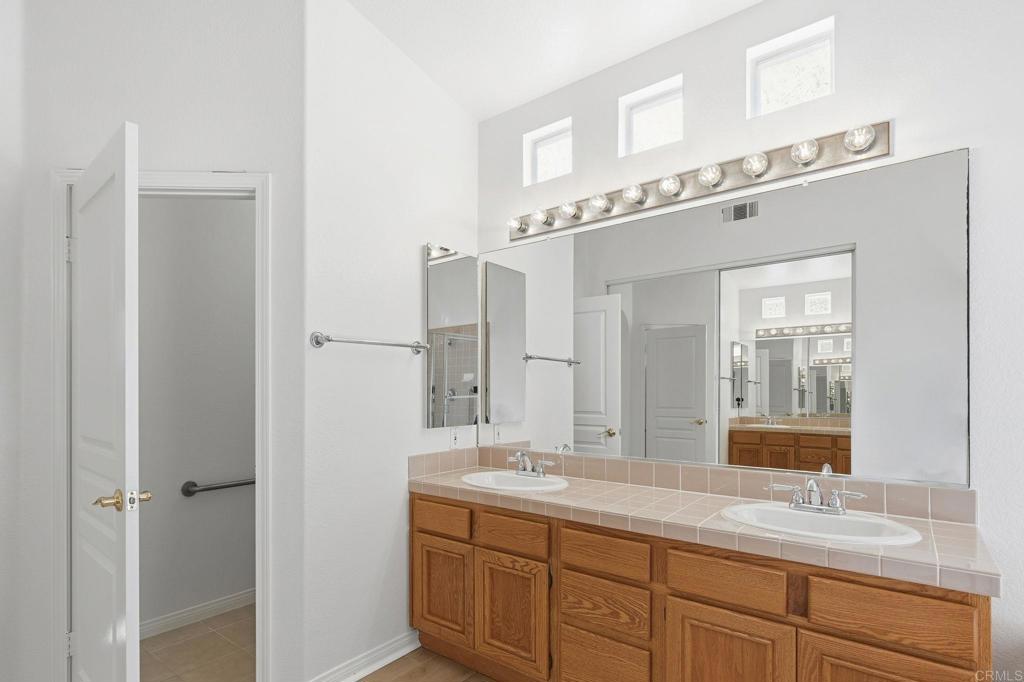 1359 Sparrow Road Carlsbad, CA 92011 - Photo 36 of 43 a bathroom with a double vanity sink and a mirror