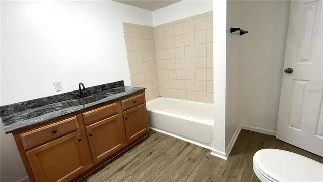 a bathroom with a granite countertop sink toilet and bathtub