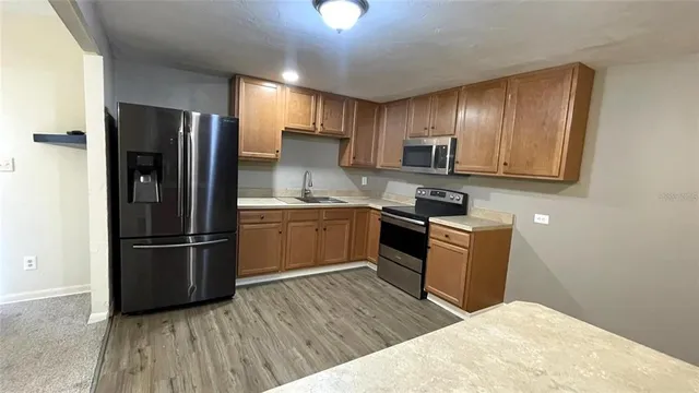 a kitchen with granite countertop stainless steel appliances and wooden cabinets