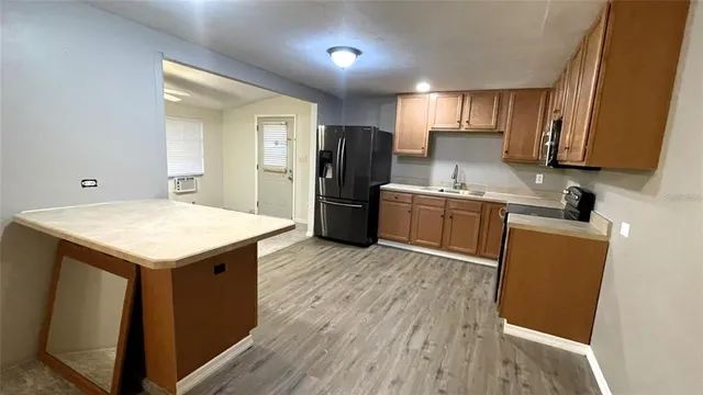 a kitchen with refrigerator cabinets and wooden floor