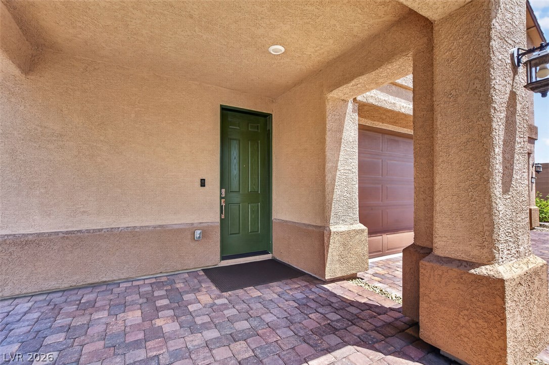 1824 Redland Ridge Street Henderson, NV 89002 - Photo 4 of 69 A welcoming front entrance featuring a green door and textured walls.
