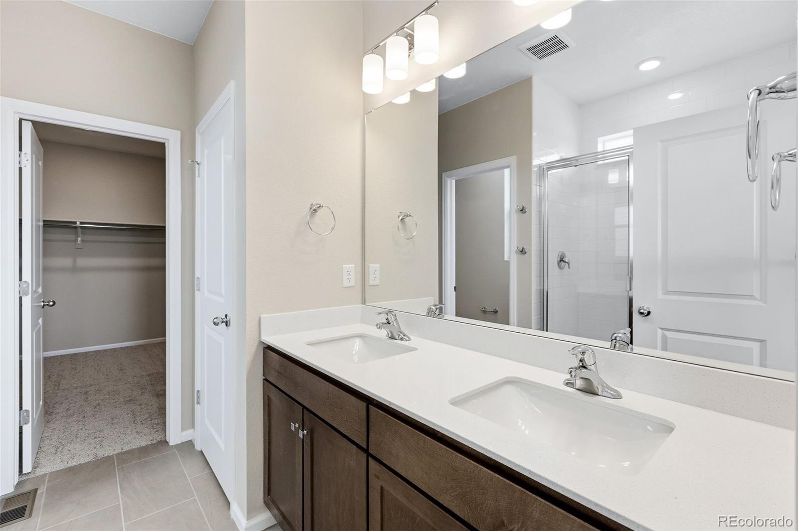6028 Keyser Place Brighton, CO 80601 - Photo 12 of 26 a bathroom with a sink double vanity and a mirror