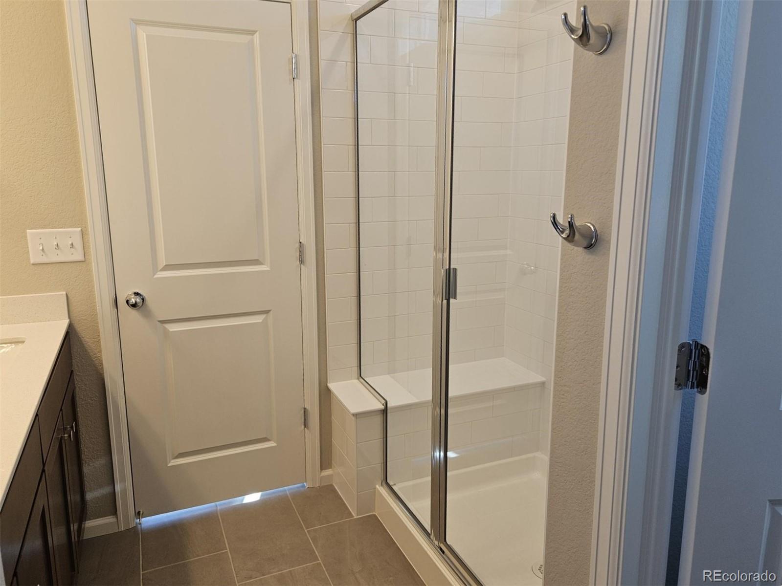 6028 Keyser Place Brighton, CO 80601 - Photo 12 of 14 a bathroom with a glass shower door