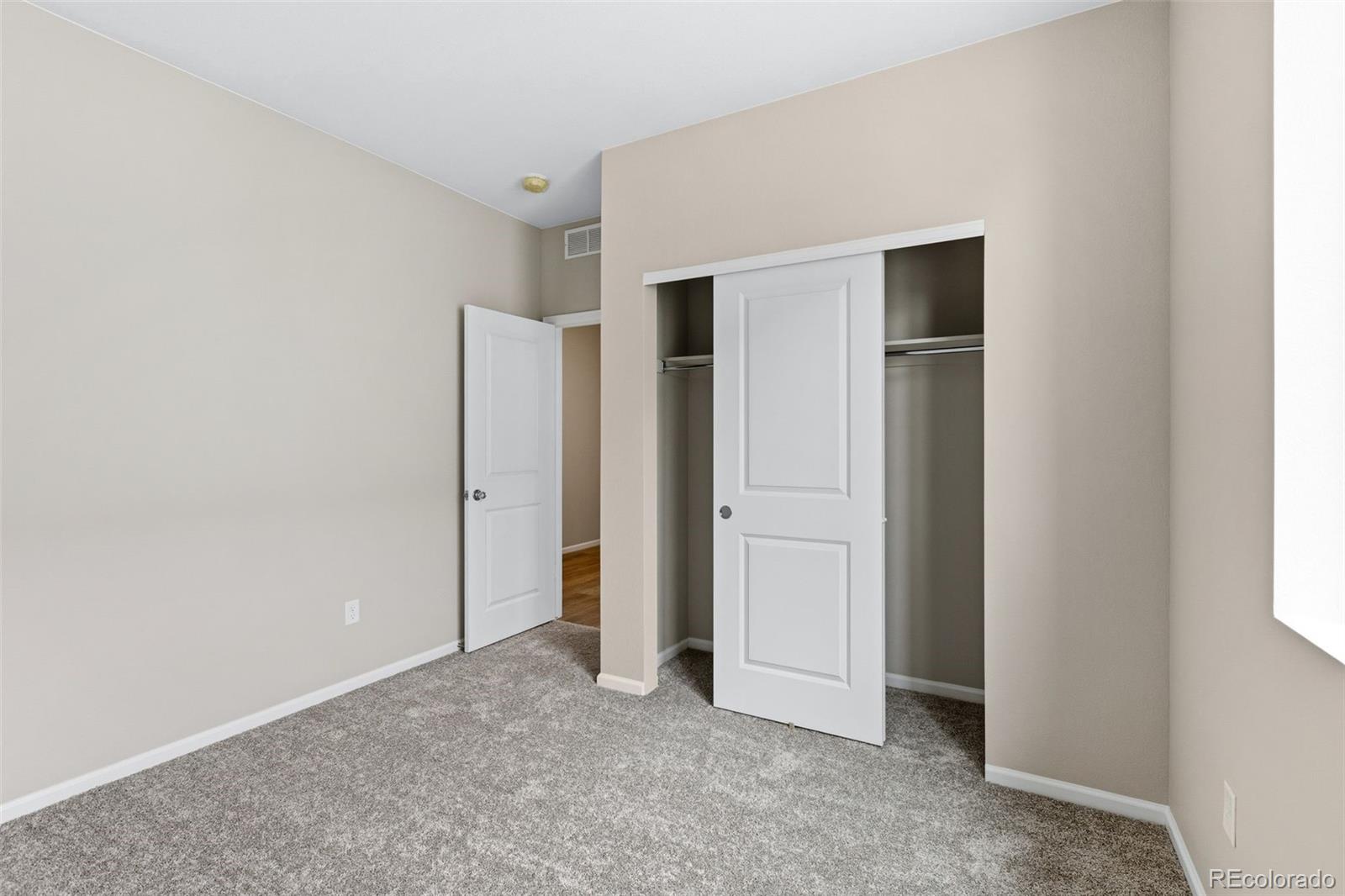 6028 Keyser Place Brighton, CO 80601 - Photo 16 of 26 an empty room with closet and windows