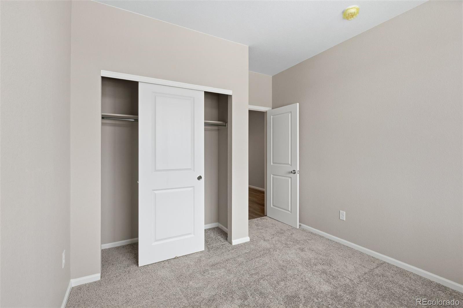 6028 Keyser Place Brighton, CO 80601 - Photo 19 of 26 a view of an empty room with closet and wooden floor