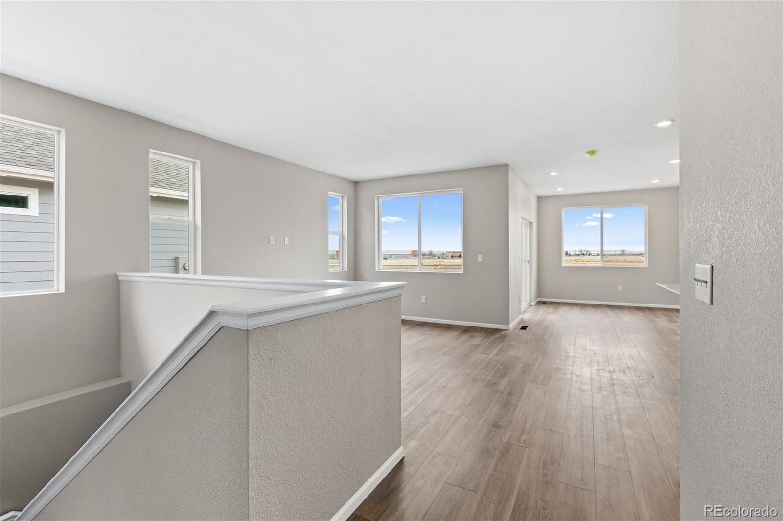 6028 Keyser Place Brighton, CO 80601 - Photo 21 of 26 a view of an empty room with a window and wooden floor