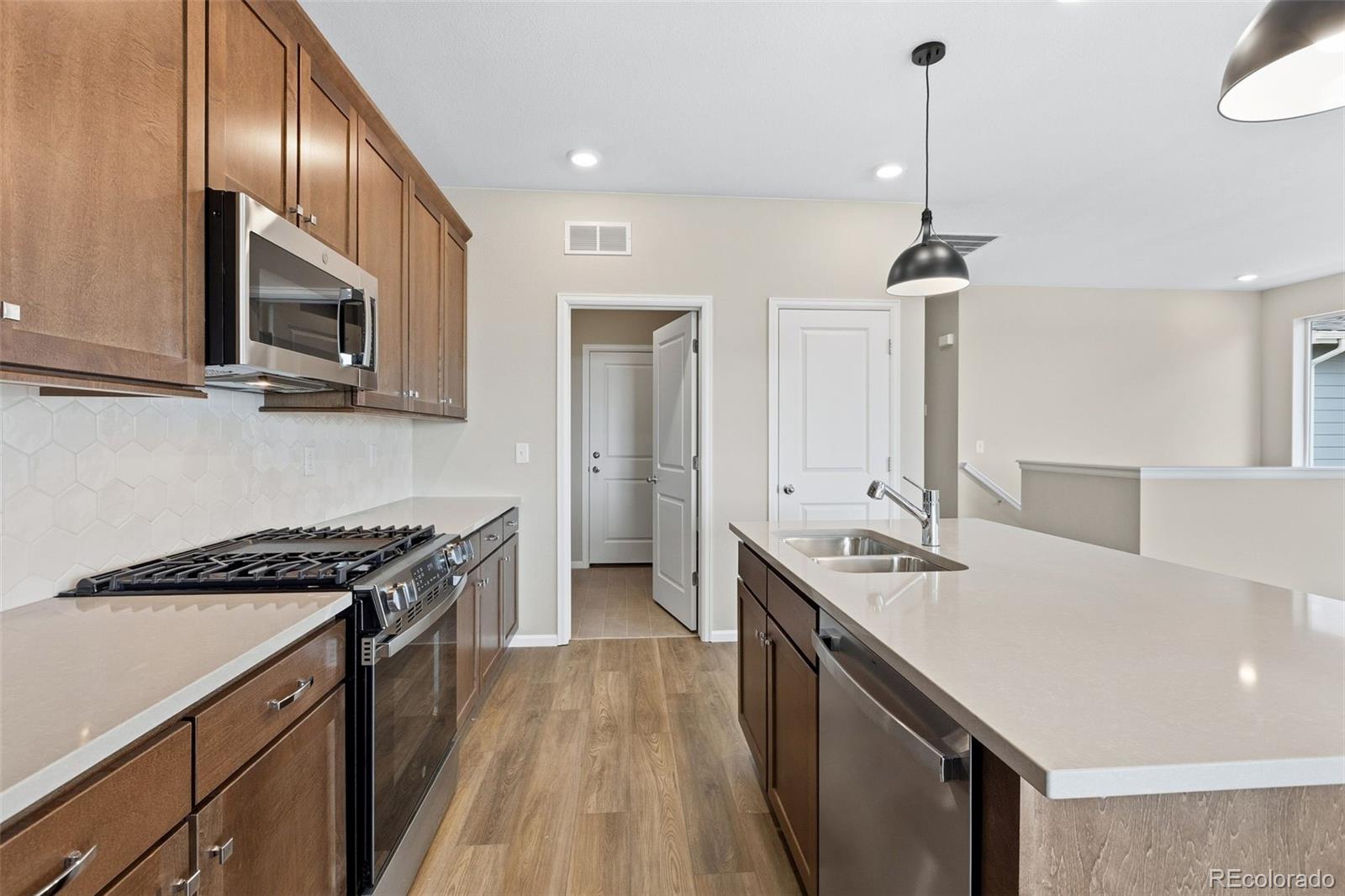 6028 Keyser Place Brighton, CO 80601 - Photo 5 of 26 a kitchen with a sink stove and microwave
