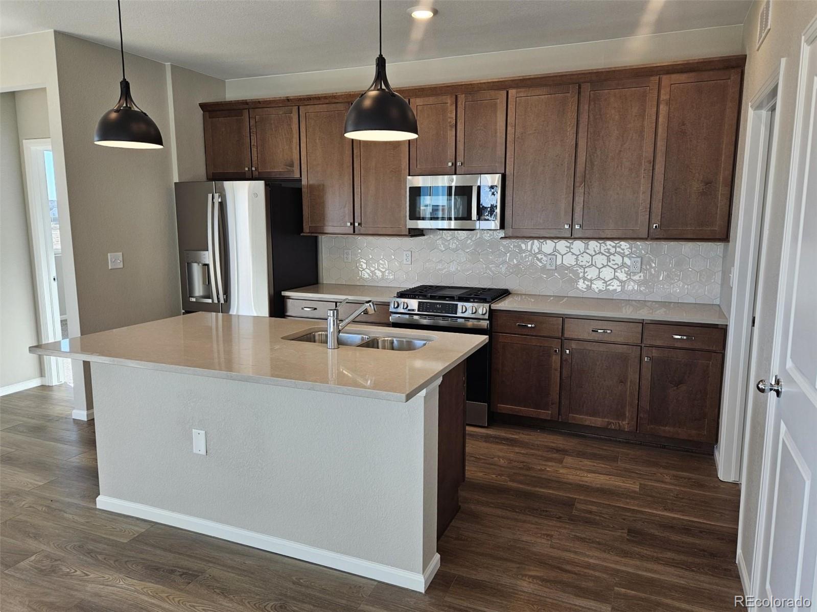 6028 Keyser Place Brighton, CO 80601 - Photo 6 of 14 a kitchen with stainless steel appliances granite countertop a sink stove and refrigerator