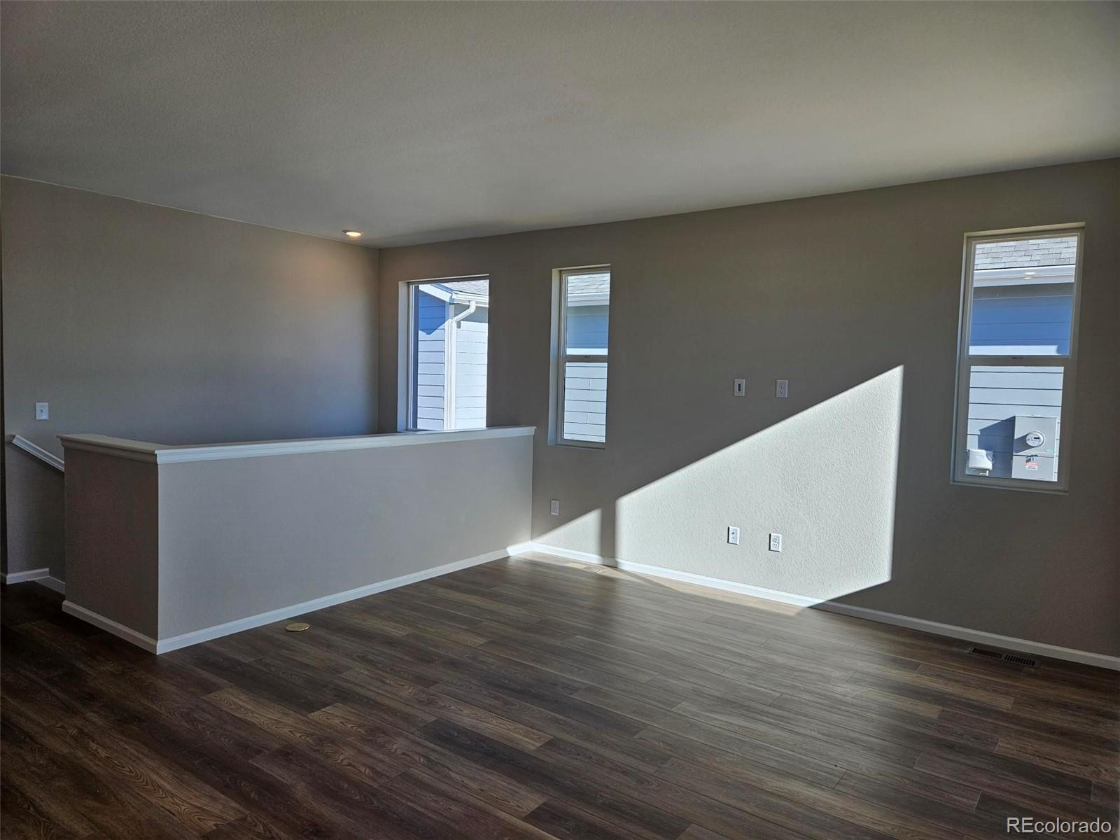 6028 Keyser Place Brighton, CO 80601 - Photo 8 of 14 an empty room with wooden floor and windows