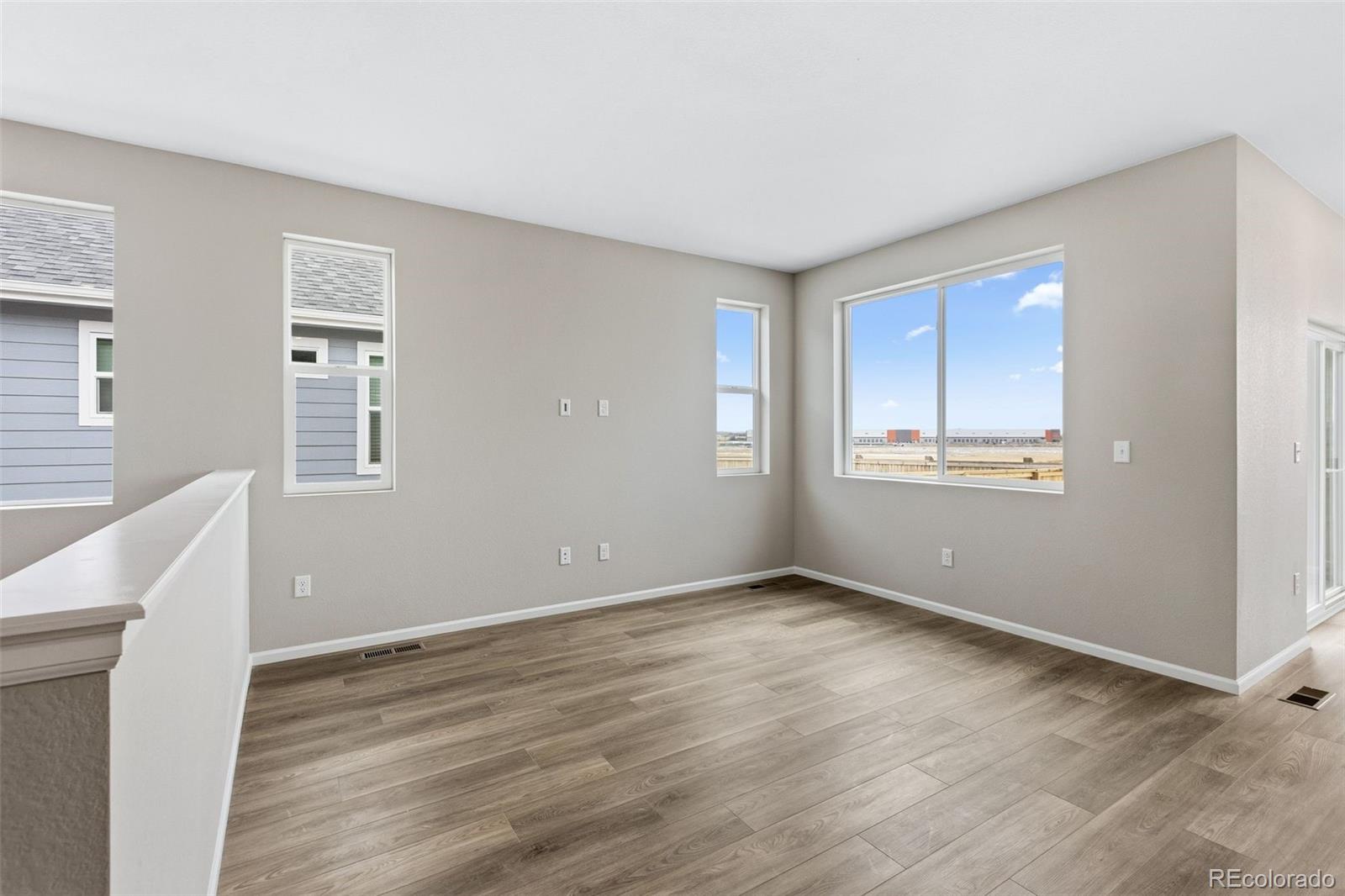 6028 Keyser Place Brighton, CO 80601 - Photo 9 of 26 a view of an empty room with wooden floor and a window
