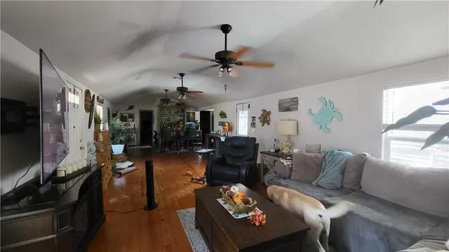 a living room with furniture a chandelier and a flat screen tv