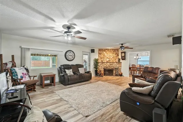 a kitchen with stainless steel appliances kitchen island granite countertop a refrigerator oven a sink dishwasher and white cabinets with wooden floor